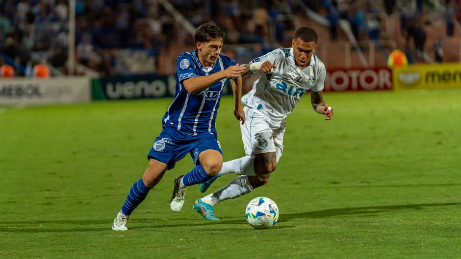 Two football players competing intensely during a soccer match on a field.