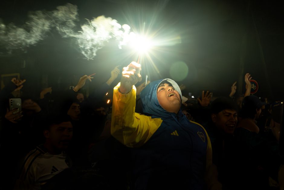 Vibrant night celebration as sports fans cheer with flares, capturing exhilarating crowd energy.