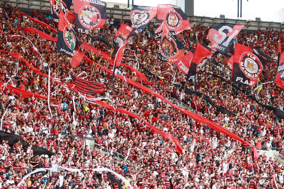 Energetic crowd of Flamengo supporters waving flags in Maracanã Stadium, Rio de Janeiro.