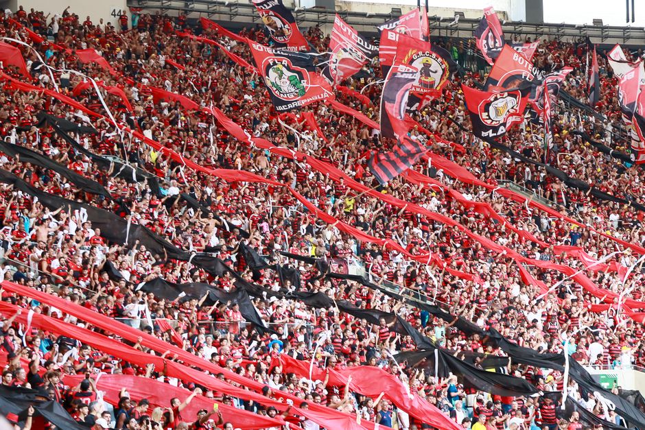 A lively crowd of football fans waving flags and banners at Maracanã Stadium, Rio de Janeiro.