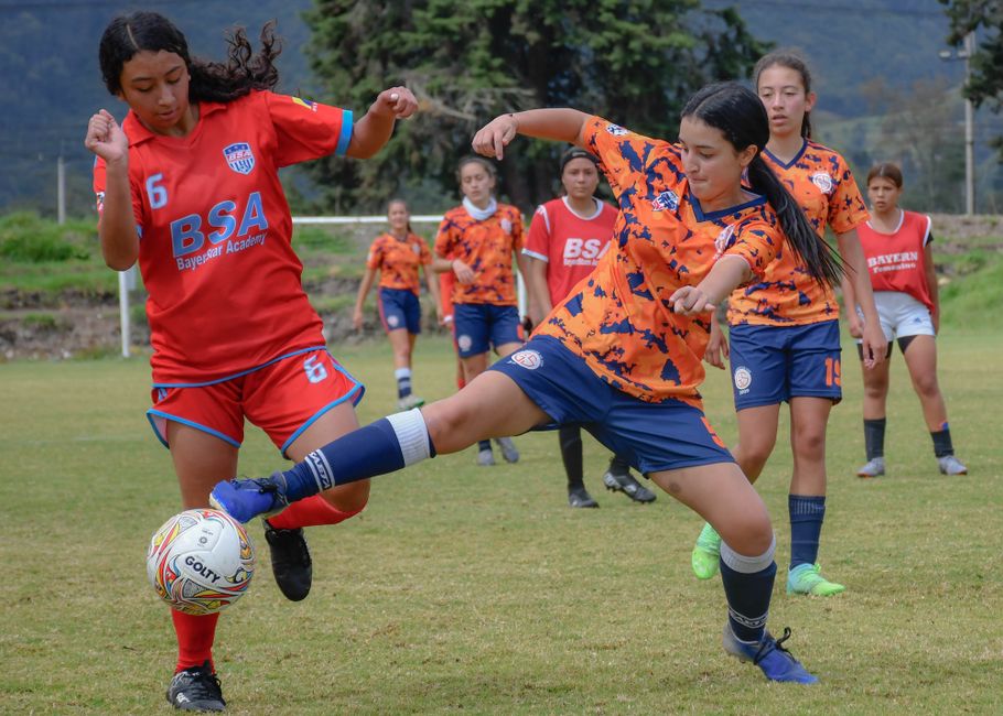 Energetic girls' soccer game showcasing skill and teamwork on a vibrant day.