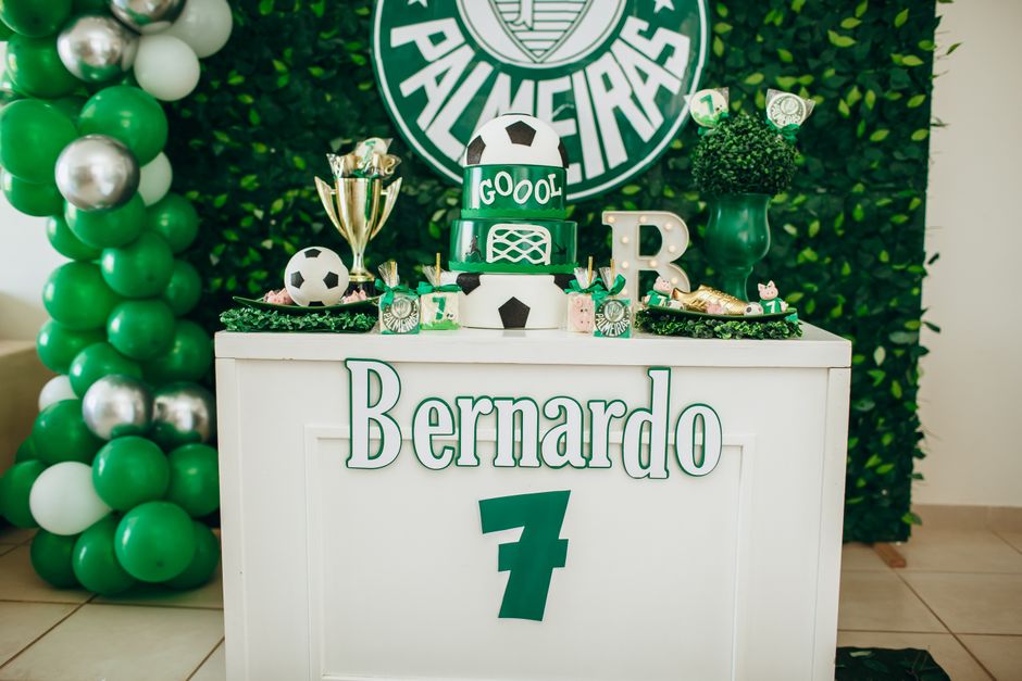 Vibrant soccer-themed birthday party setup featuring balloons, a cake, and decorations with a football theme.