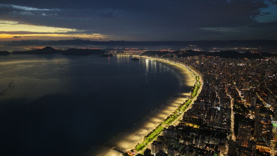 Stunning aerial night view of the illuminated Santos beachfront in São Paulo, Brazil.