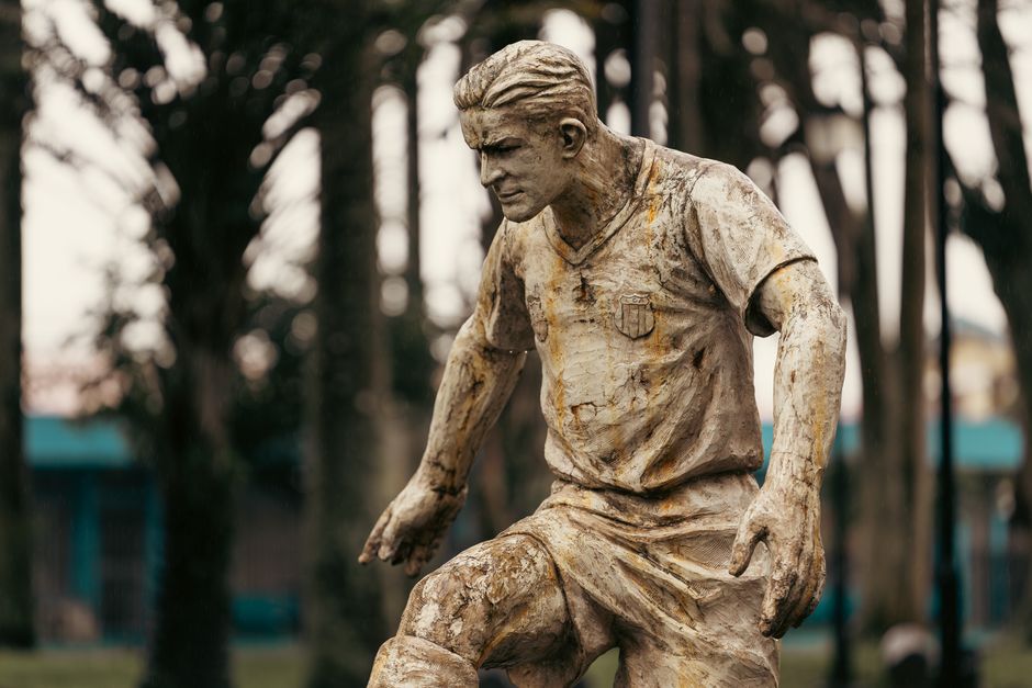 A rustic statue of a soccer player captured in a park in Alajuela, Costa Rica.