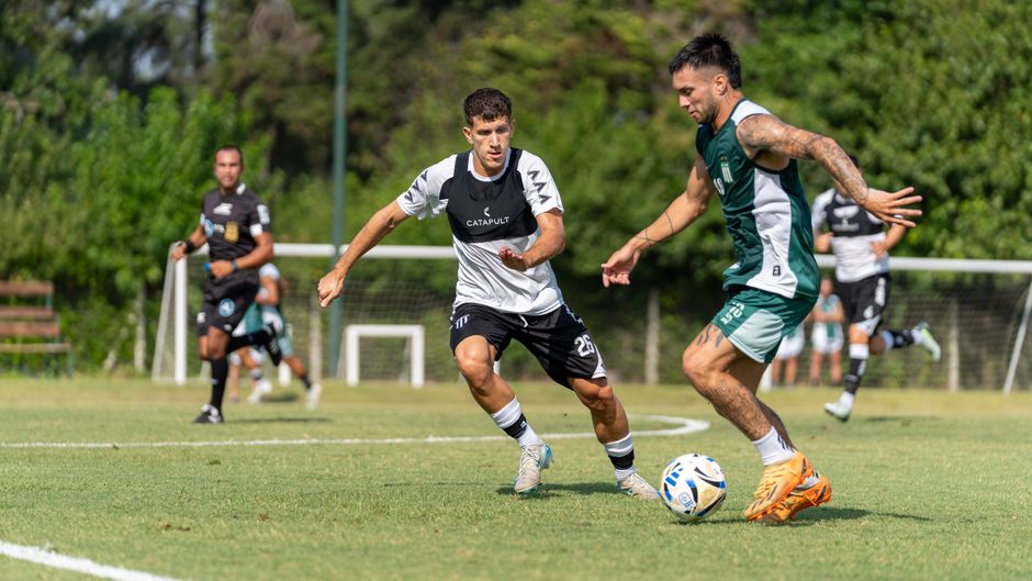 Two soccer players in action on a sunny day, showcasing athleticism on the field.